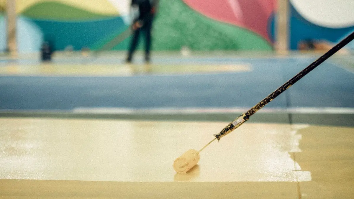 Roller applying a protective floor coating